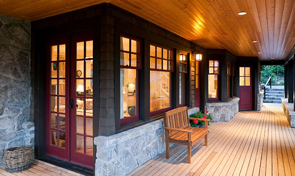 Modern outdoor wooden porch with recessed lighting and wall sconces